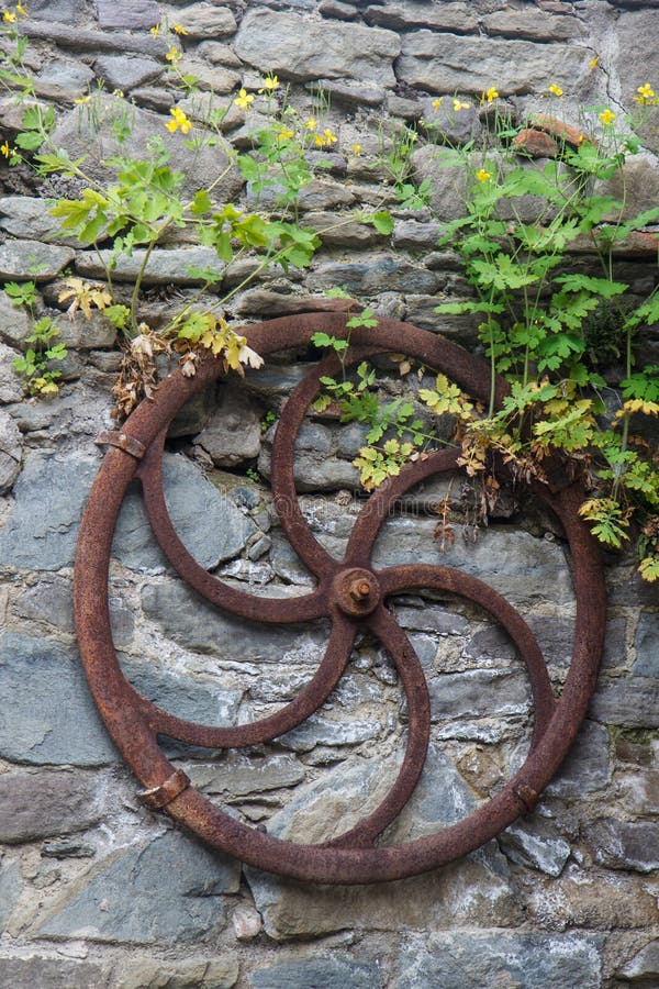 Decorazione del giardino con la vecchia ruota di legno del carretto immagine stock Decorazione del giardino con la vecchia ruota di legno del carretto immagine stock