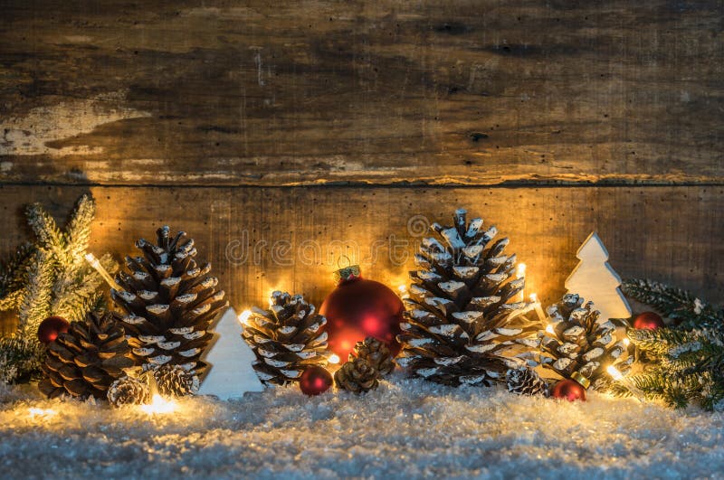 Decorazione di Natale di Snowy con le pigne naturali, il verde, le palle e le luci su neve con immagini stock libere da diritti Decorazione di Natale di Snowy con le pigne naturali, il verde, le palle e le luci su neve con immagini stock libere da diritti
