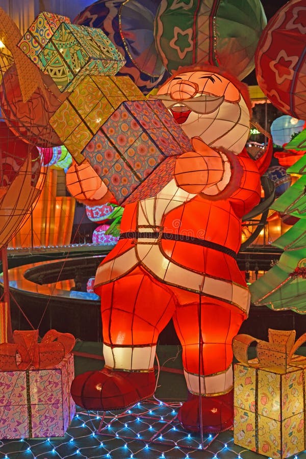 Decorazione leggera variopinta di Santa Claus che ride che sembra i mucchi di trasporto felici dei contenitori di regalo fotografia stock