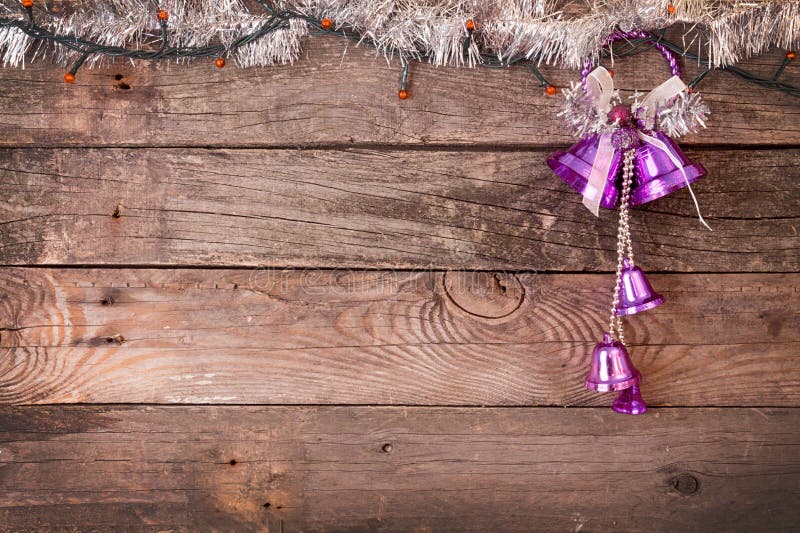 Decorazioni di natale Campane porpora e ghirlanda elettrica sul wo fotografia stock Decorazioni di natale Campane porpora e ghirlanda elettrica sul wo fotografia stock