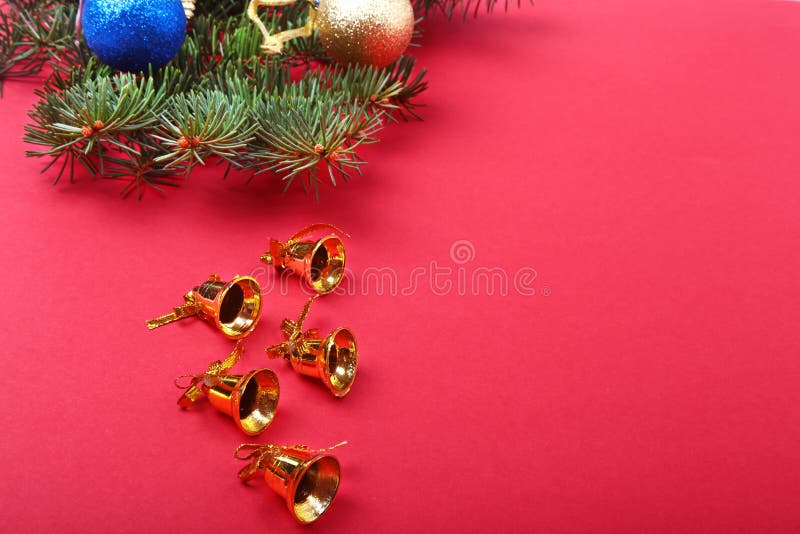 Decoração do Natal com os sinos bonitos do ouro, as bolas coloridas e as fitas no fundo vermelho fotos de stock Decoração do Natal com os sinos bonitos do ouro, as bolas coloridas e as fitas no fundo vermelho fotos de stock