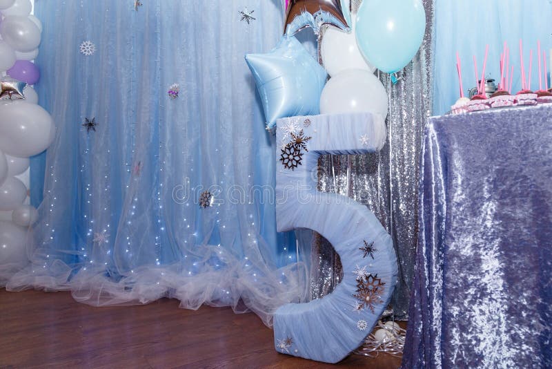 Decorations and candy bar for winter birthday. Number 5 with snowlakes and balloons. Frozen cartoon character thematic party. Decorations and candy bar for winter birthday. Number 5 with snowlakes and balloons. Frozen cartoon character thematic party