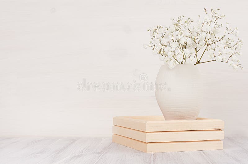 Decoração home macia das flores pequenas brancas no vaso cerâmico no fundo de madeira branco imagem de stock royalty free Decoração home macia das flores pequenas brancas no vaso cerâmico no fundo de madeira branco imagem de stock royalty free