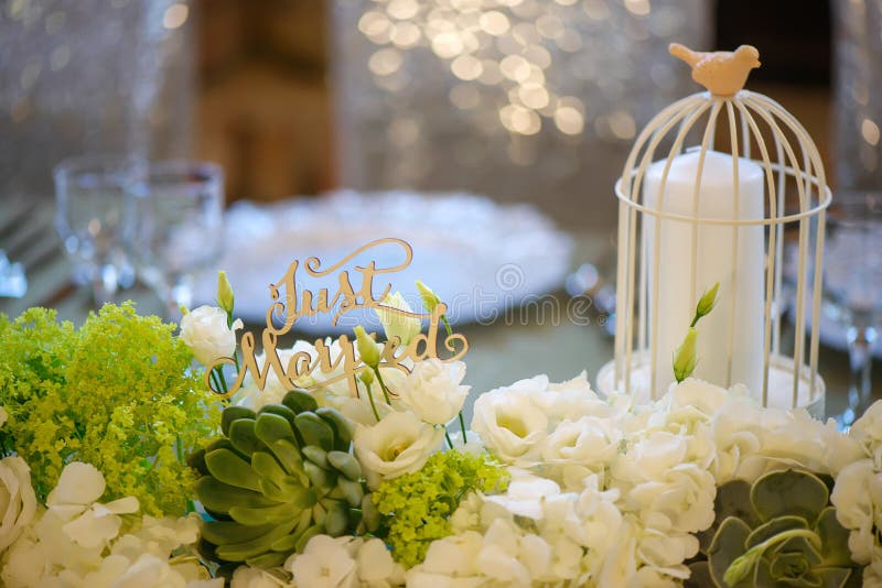 Decoração romântica do casamento para a tabela de jantar dos noivos com a gaiola de pássaro decorativa do vintage branco que guar imagem de stock Decoração romântica do casamento para a tabela de jantar dos noivos com a gaiola de pássaro decorativa do vintage branco que guar imagem de stock