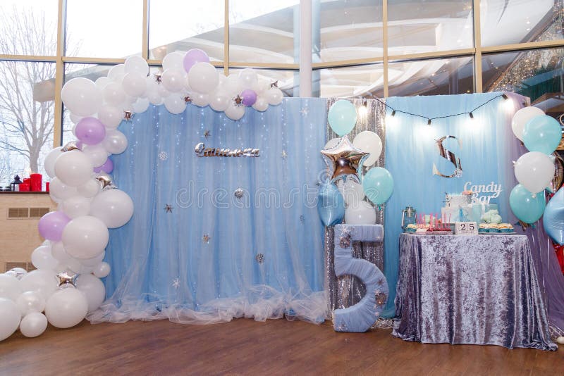 Izmail, Ukraine - February 2019. Decorations and candy bar with cake and cupcakes for winter birthday. Number 5 with snowlakes and balloons. Frozen cartoon character thematic party. Izmail, Ukraine - February 2019. Decorations and candy bar with cake and cupcakes for winter birthday. Number 5 with snowlakes and balloons. Frozen cartoon character thematic party