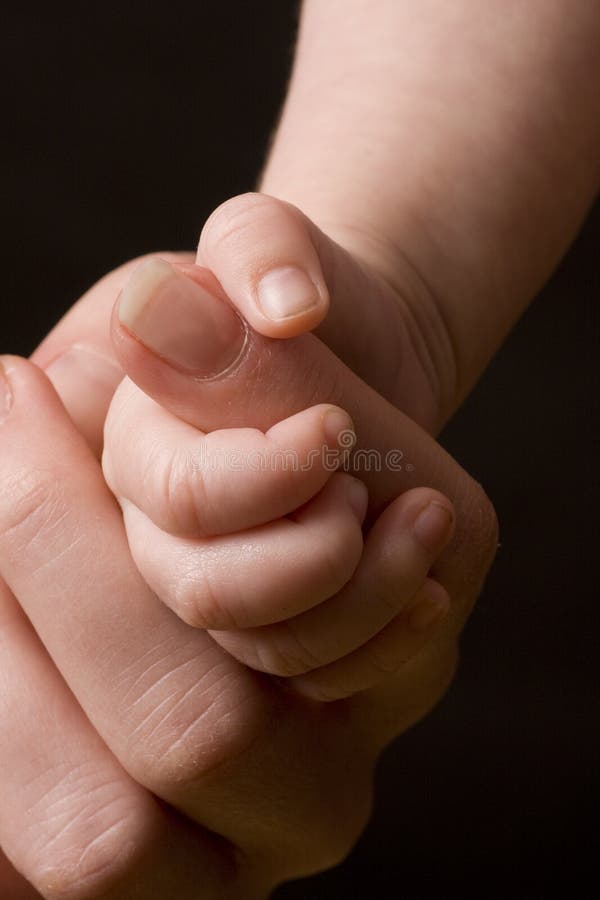 Dedo adulto emocionante da mão do bebê