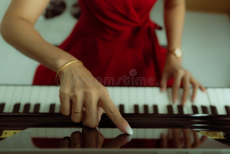 Finger of woman touching on tablet computer screen for basic piano video lessons while online learning how to play. Concept of new skill for quarantine people at home during coronavirus outbreak. Finger of woman touching on tablet computer screen for basic piano video lessons while online learning how to play. Concept of new skill for quarantine people at home during coronavirus outbreak