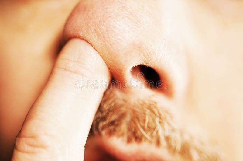 Dedo do homem no nariz