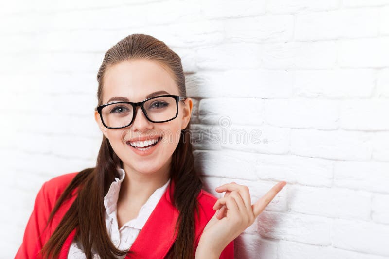 Dedo do ponto da mulher de negócios até dos vidros vermelhos do revestimento do desgaste do espaço da cópia o sorriso feliz fotos de stock Dedo do ponto da mulher de negócios até dos vidros vermelhos do revestimento do desgaste do espaço da cópia o sorriso feliz fotos de stock