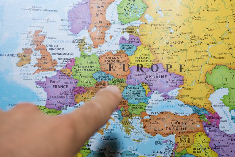 Dedo que aponta a um mapa colorido do pa?s de Europa que decide que pa?s ?s f?rias e ao curso imagem de stock Dedo que aponta a um mapa colorido do pa?s de Europa que decide que pa?s ?s f?rias e ao curso imagem de stock