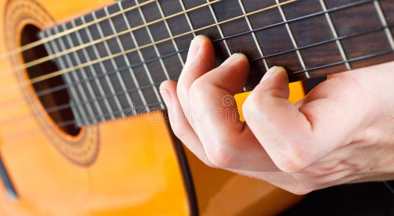 Dedos masculinos que tocan la guitarra fotos de archivo Dedos masculinos que tocan la guitarra fotos de archivo