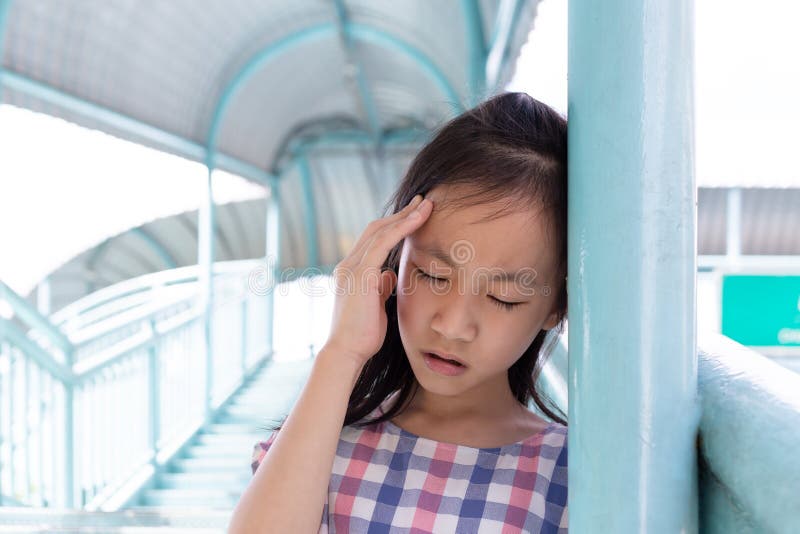 Communicates the symptoms of vertigo,dizziness,migraine,sick depressed girl suffering from headache,Asian girl on the pedestrian overpass. Communicates the symptoms of vertigo,dizziness,migraine,sick depressed girl suffering from headache,Asian girl on the pedestrian overpass