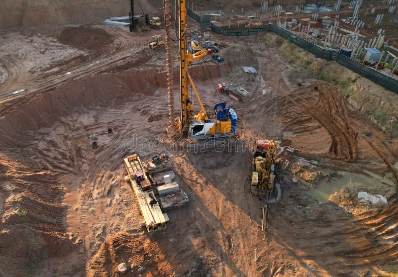 Deep foundation machine. Drilling rig and Pile driver at construction site. Pile driven into ground by vibrating hydraulic hammer stock image