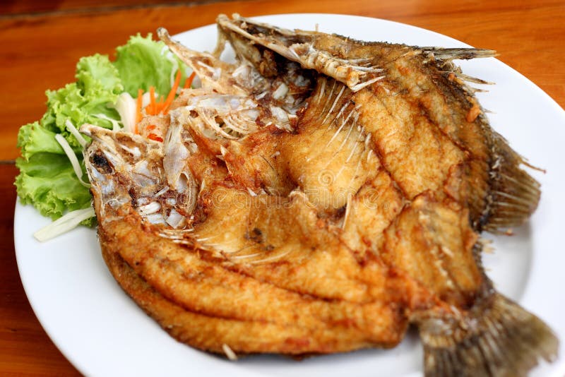 Deep fried fish with vegetables on white dish