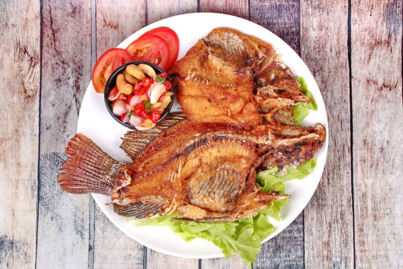 Deep Fried Tilapia with Spicy and Sour Herb Salad . Stock Photo Image