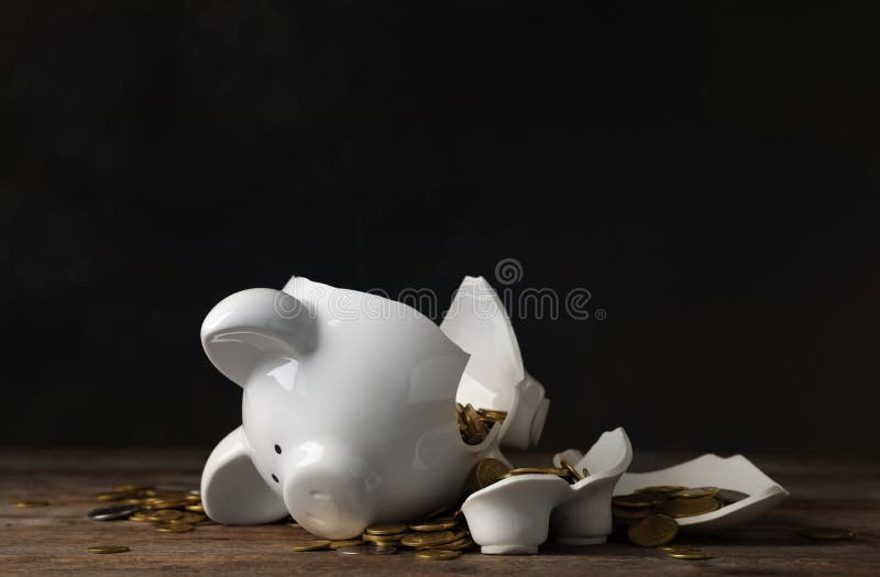 Broken piggy bank with money on table against dark background. Broken piggy bank with money on table against dark background