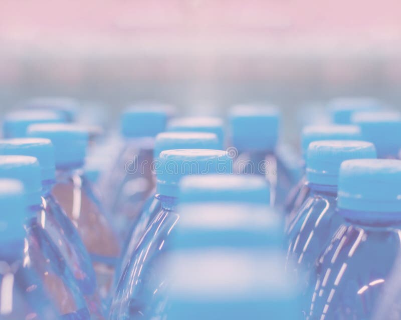 Defocus Background, Blue Caps Set Bottled Water. Pure Drinking Water in