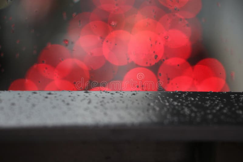 Defocus czerwone światło zamazywał tło na nawierzchniowym szkle z deszczem fotografia royalty free Defocus czerwone światło zamazywał tło na nawierzchniowym szkle z deszczem fotografia royalty free