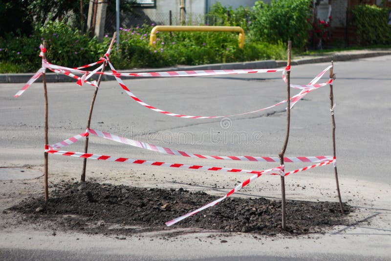 Defocus repair road. Red and white barrier tape protect. Road repair sign. Roadwork warning signs on the roadside