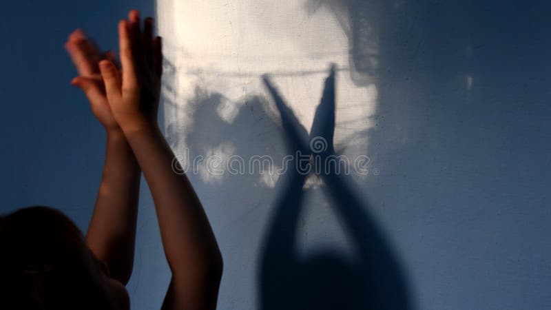 Defocus shadows of kid clapping hands on stucco wall surface with copy space. Halloween concept royalty free stock photos