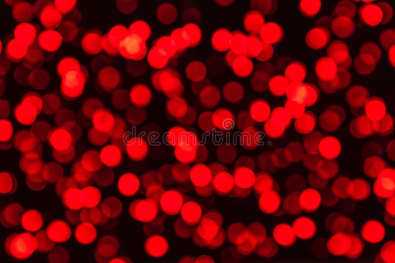 Defocused image of illuminated red circles of lights on a dark background strong bokeh effect