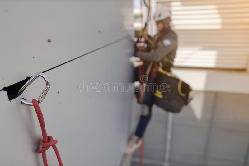 Defocused Rope Access Wearing Full Safety Body Harness Removing Wall