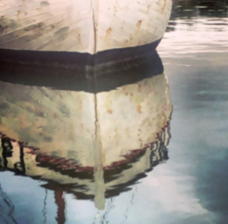 Defocused white boat reflecting in water