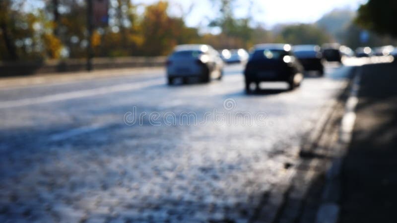 Defocusverkeer op een weg De herfst Auto's bij zonnige ochtend