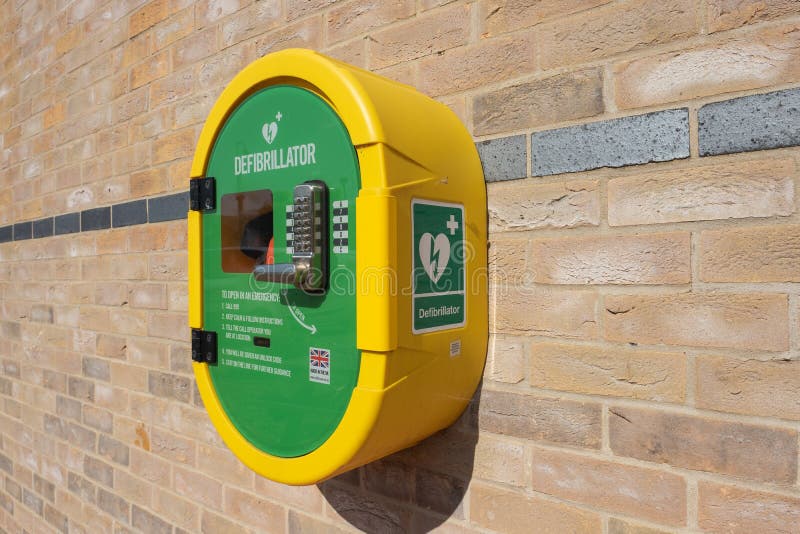 Defribulator seen attached to an outside community hall wall.