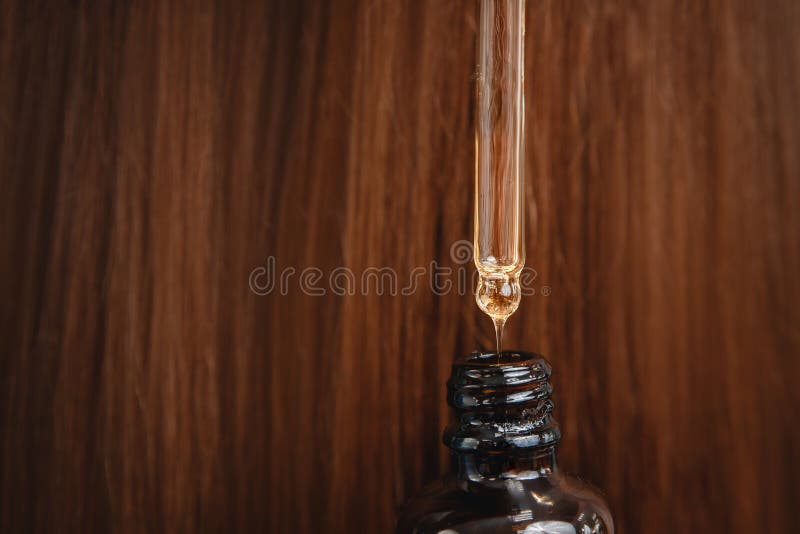 Deixe cair a restauração e a recuperação do óleo no fundo do cabelo danificado após o sol Sal?o de beleza dos termas do cabeleire imagens de stock royalty free Deixe cair a restauração e a recuperação do óleo no fundo do cabelo danificado após o sol Sal?o de beleza dos termas do cabeleire imagens de stock royalty free