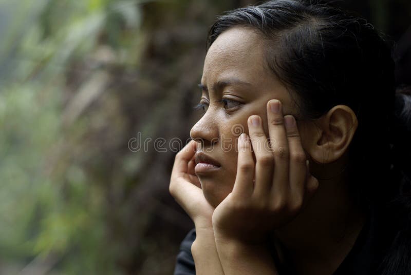 Sad asian teen girl chin on hands royalty free stock images