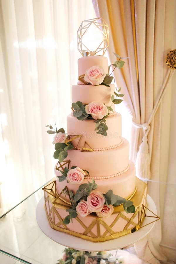 Beautiful wedding cake decorated with flowers. Pink color of cake. Powder rose. Beautiful wedding cake decorated with flowers. Pink color of cake. Powder rose.