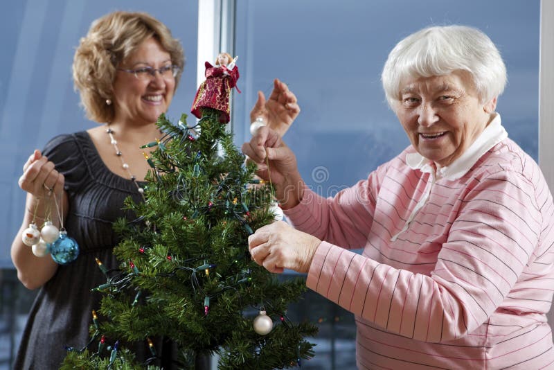 Dekorerar den hjälpande pensionären för volontären henne jul Tr
