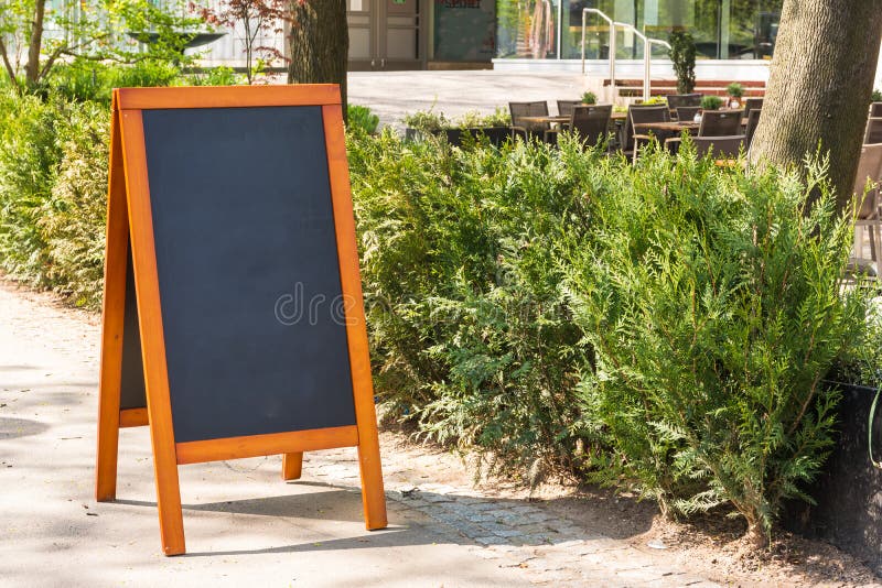 Del café de la pizarra de la acera de los arbustos ciudad en blanco Restau urbano al aire libre imagenes de archivo Del café de la pizarra de la acera de los arbustos ciudad en blanco Restau urbano al aire libre imagenes de archivo