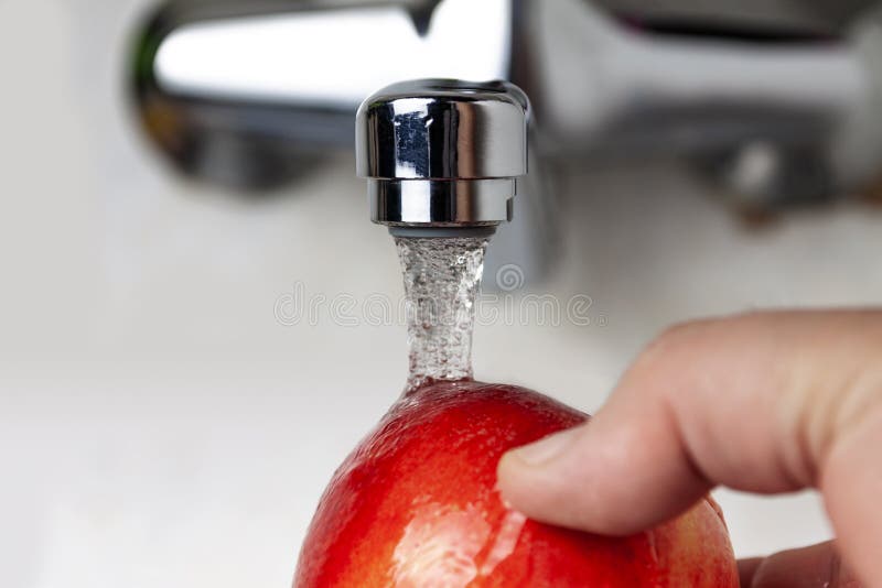 Del golpecito vierte el agua en Apple imágenes de archivo libres de regalías Del golpecito vierte el agua en Apple imágenes de archivo libres de regalías