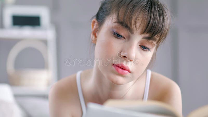 Del primer del retrato del adolescente de la mujer interior joven del libro de lectura entusiasta en casa almacen de metraje de vídeo
