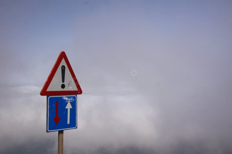 Del Río - Lanzarote de Mirador: El tráfico aislado de la manera del für uno de la señal de peligro sobre las nubes se centra en m imágenes de archivo libres de regalías Del Río - Lanzarote de Mirador: El tráfico aislado de la manera del für uno de la señal de peligro sobre las nubes se centra en m imágenes de archivo libres de regalías