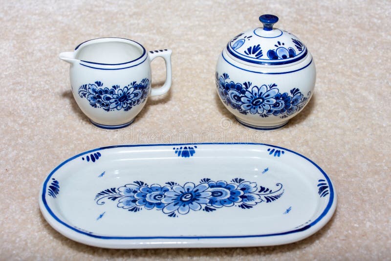 Delft Blue Tea en Sugar porcelain serende gerechten naast een lade Souvenir uit Nederland Sluiten over beige royalty-vrije stock afbeelding Delft Blue Tea en Sugar porcelain serende gerechten naast een lade Souvenir uit Nederland Sluiten over beige royalty-vrije stock afbeelding