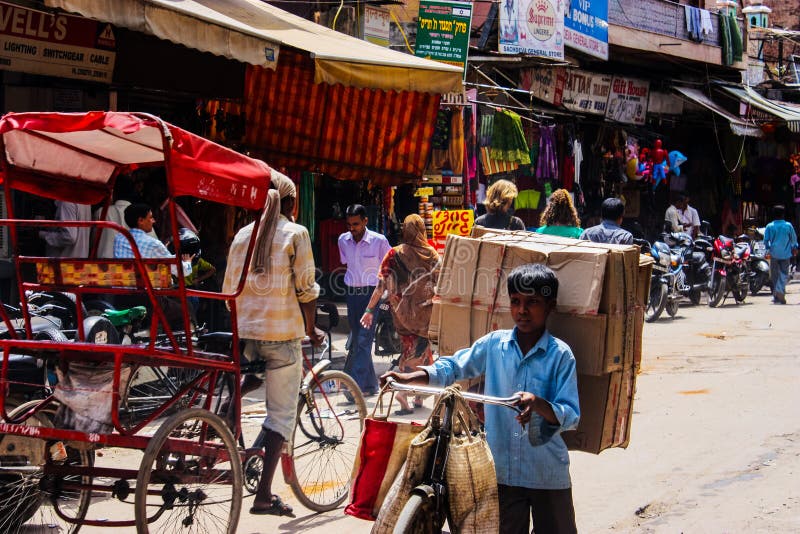Delhi, India - 18 agosto 2009: india, bambino porta scatole di carta su una bicicletta in una strada di delhi fotografia stock Delhi, India - 18 agosto 2009: india, bambino porta scatole di carta su una bicicletta in una strada di delhi fotografia stock