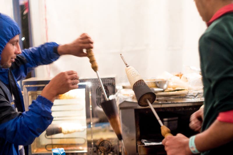 People in blue uniforms putting cone pizzas on a stick into the oven for preparation royalty free stock images People in blue uniforms putting cone pizzas on a stick into the oven for preparation royalty free stock images