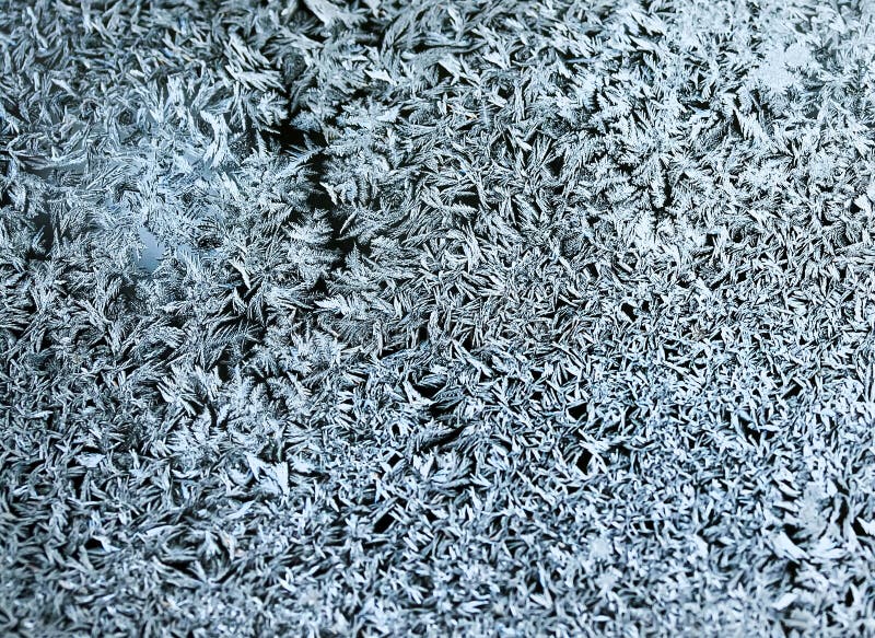 Delicate patterns of frost crystals on a sparkling glass royalty free stock photo