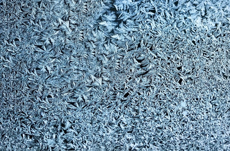 Delicate patterns of frost crystals on a sparkling glass royalty free stock image