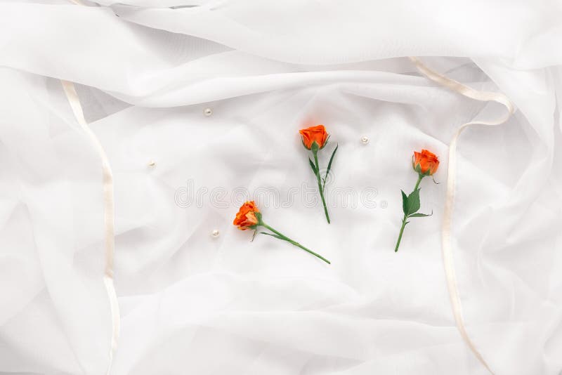 Delicate wedding background, chiffon, roses and pearls. Texture of a wedding dress close up. Top view, flat lay. Invitation or greeting card.