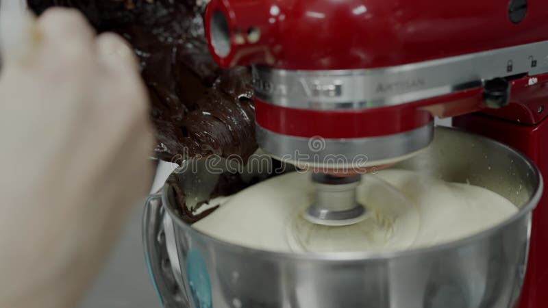 Deliciosa crema de chocolate y vainilla mezclada en una mezcla roja almacen de metraje de vídeo
