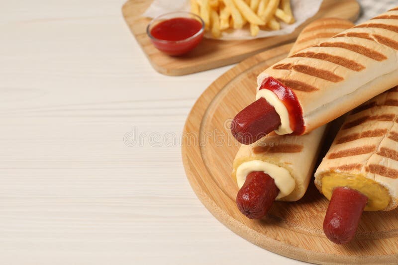 Deliciosas papas fritas de perritos calientes y salsa de baño sobre mesa de madera blanca. espacio para texto fotografía de archivo