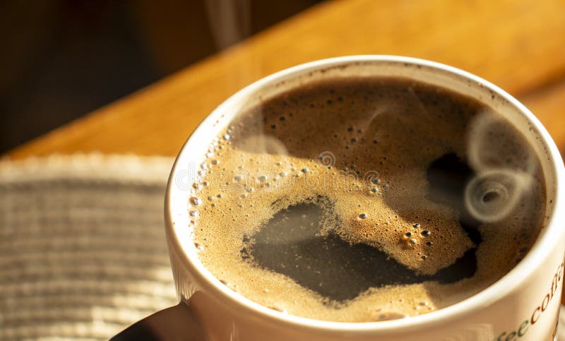 Delicioso café caliente con espuma en una taza para oficina en casa.