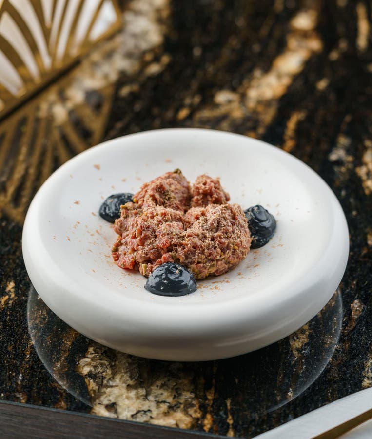 Delicioso tartar de carne de ternera con pepino en picante y salsa de trufa en la mesa de mármol con copas de vino. alimento salud imágenes de archivo libres de regalías