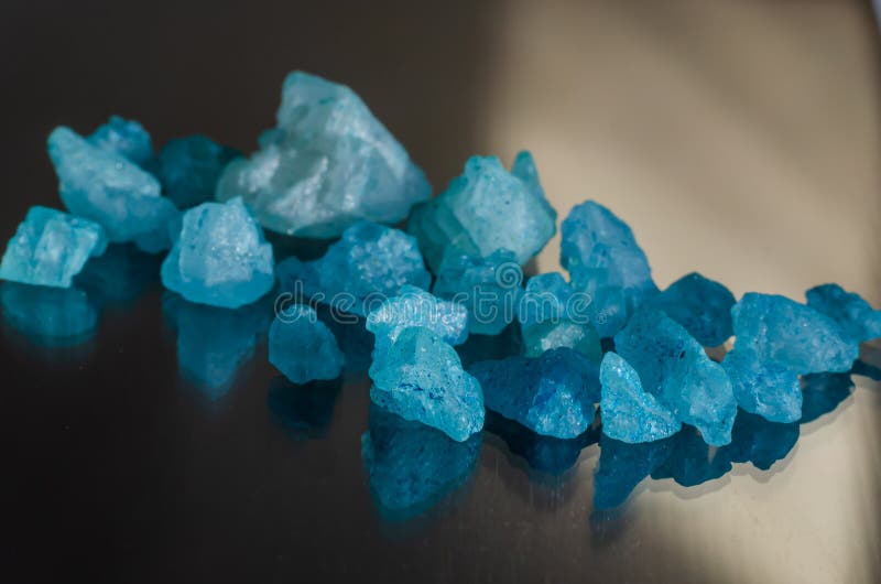 Deliciosos cristales azules de sal sobre vidrio negro en los rayos de luz solar. Foto macro foto de archivo Deliciosos cristales azules de sal sobre vidrio negro en los rayos de luz solar. Foto macro foto de archivo