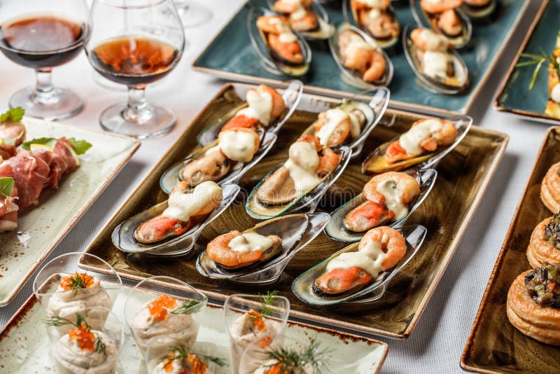 Delicious appetizers with mussels, shrimp and cheese sauce on banquet table. Gourmet food close up, snack, antipasti stock photography Delicious appetizers with mussels, shrimp and cheese sauce on banquet table. Gourmet food close up, snack, antipasti stock photography