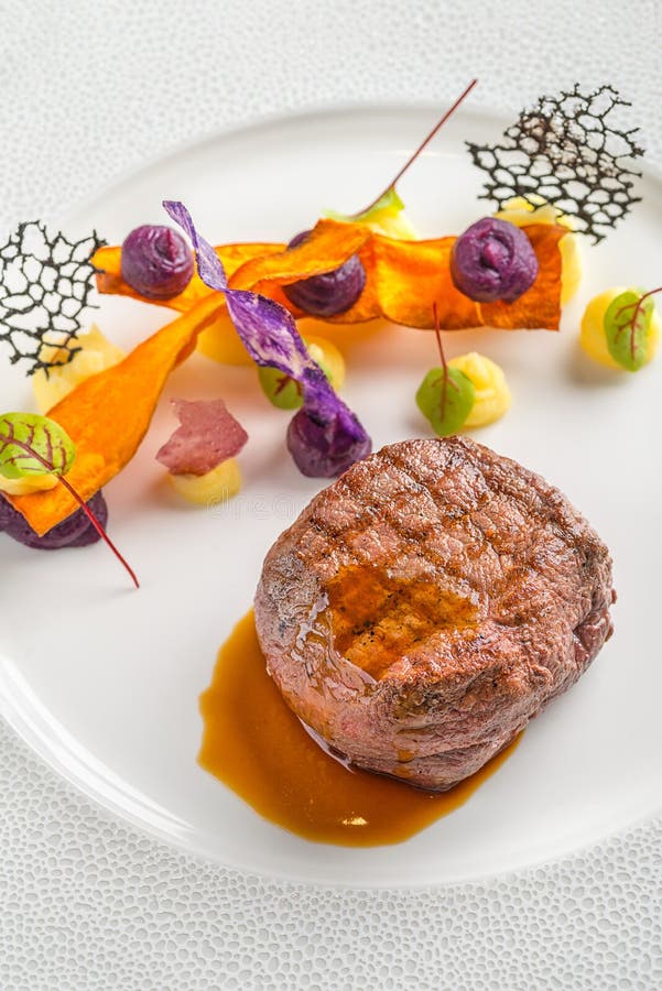 Delicious beef steak with sauce and vegetable, served on white plate, modern gastronomy, michelin restaurant
